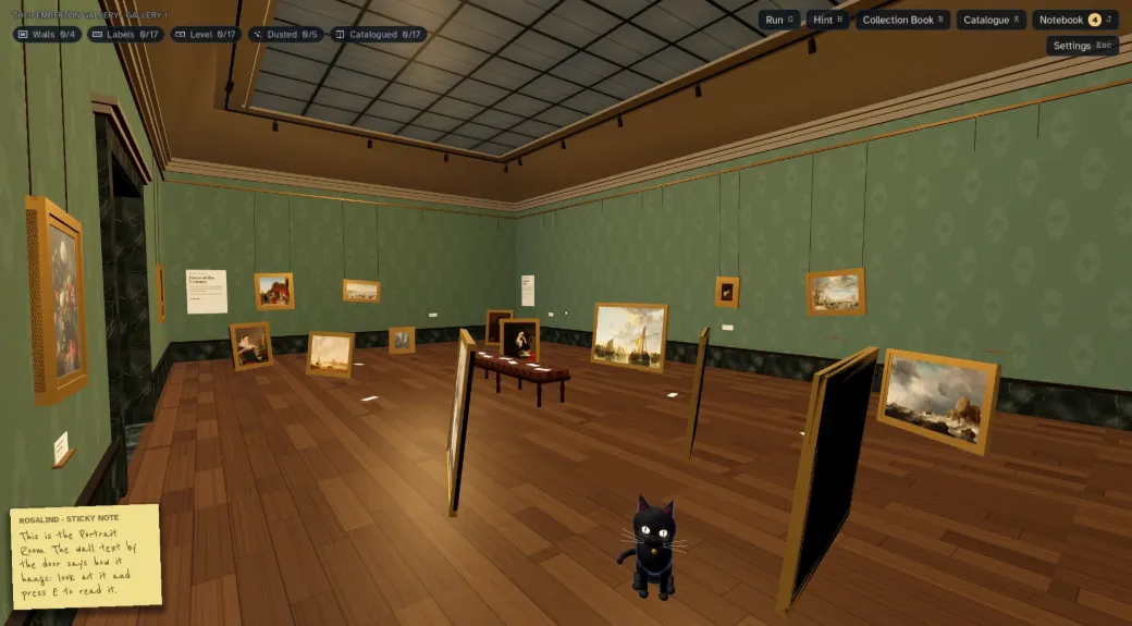 Gallery 1, with green damask walls. Paintings in gold frames lean against the walls and stand on the wooden floor, waiting to be hung. A sticky note from Rosalind says the wall text by the door explains how the room hangs.